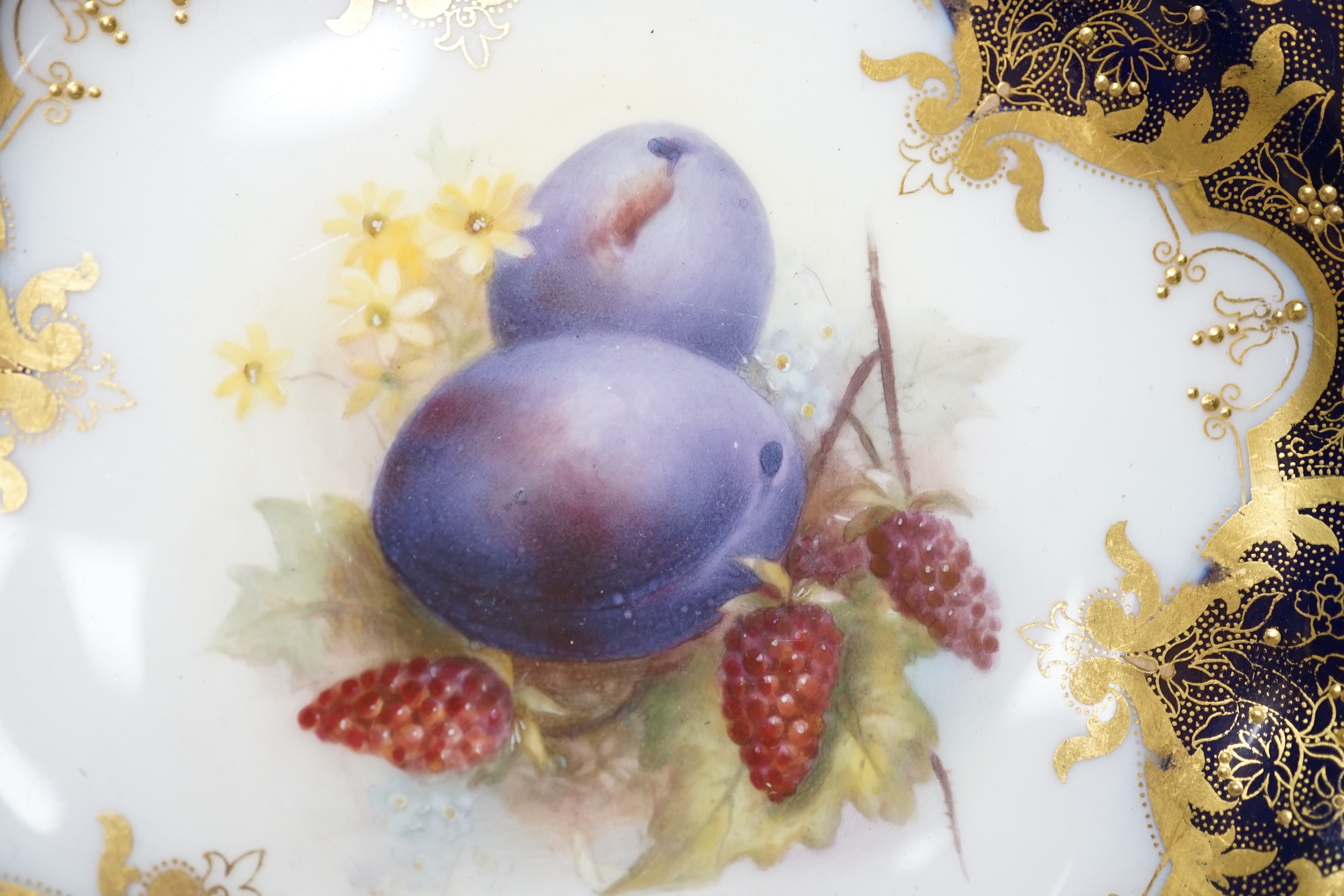 A Royal Worcester plate painted with fruit and berries by R. Sebright, signed, under a blue and gilt ground, date mark 1918